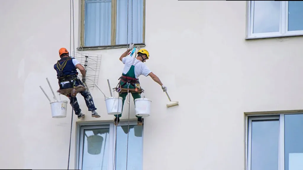 Pintor revisando una pared antes de pintar en Torredonjimeno